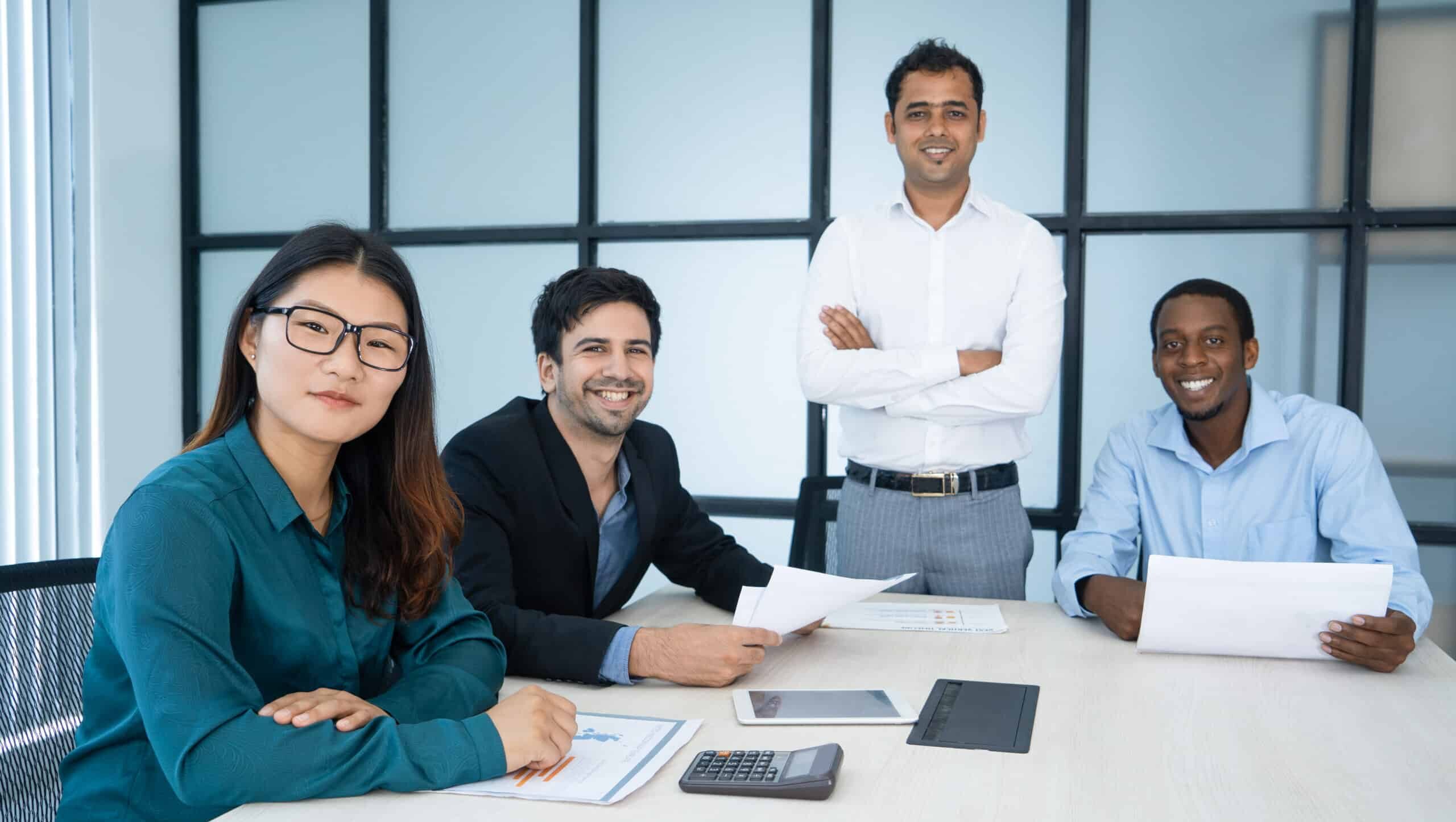directeurs-ventes-optimistes-gais-analysant-rapport-regardant-camera-dans-salle-conseil-scaled-e1692704186712.jpg